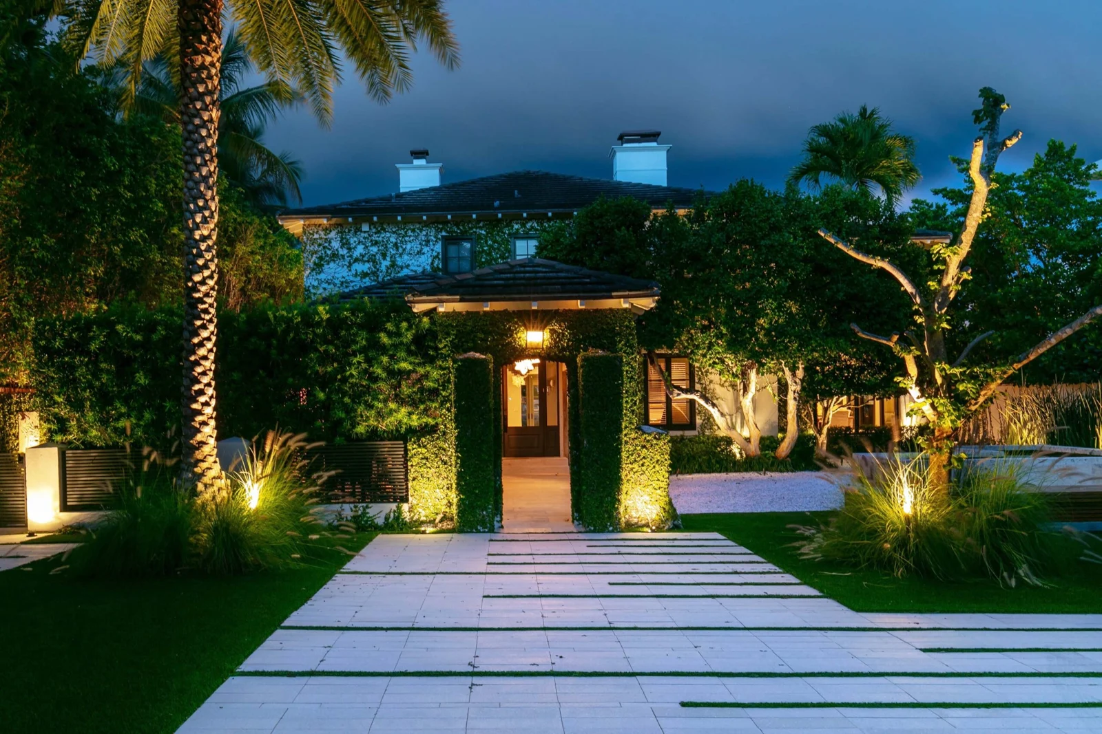 Bal Harbour residence with illuminated palms and entrance landscaping